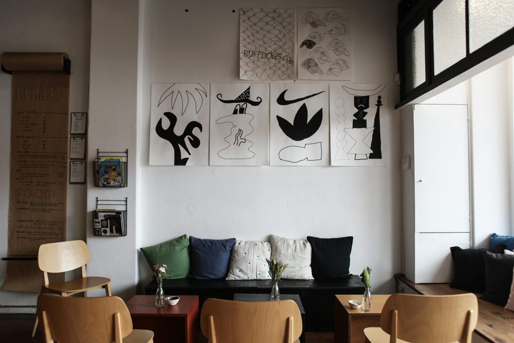Modern café interior showcasing artistic wall decor, cozy seating, and a minimalist atmosphere.